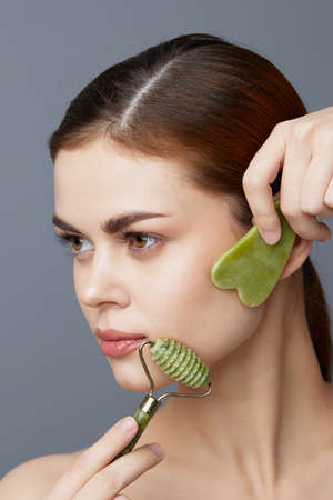 young woman jade face massager wrinkle smoothing isolated backgroundの写真素材