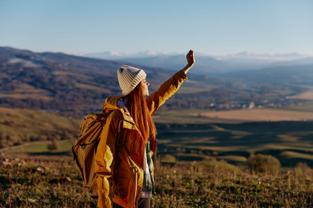woman tourist in a yellow jacket in a hat backpack travel mountains relaxationの写真素材