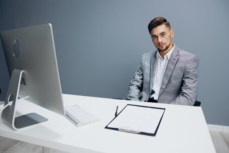 businessmen in a gray suit sits in front of a computer technologies