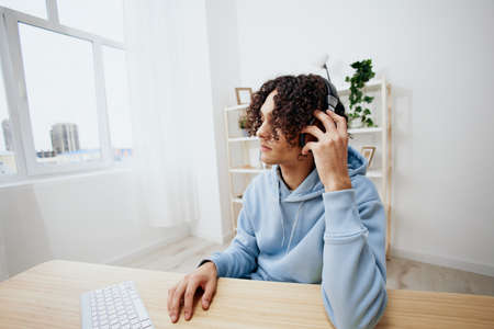 handsome guy sitting at a table in front of a computer music interiorの写真素材