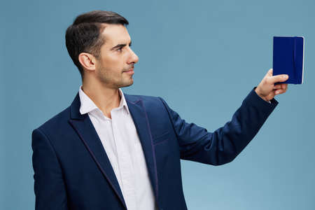 handsome businessman blue notepad in a modern suit emotion self-confidence official business and...