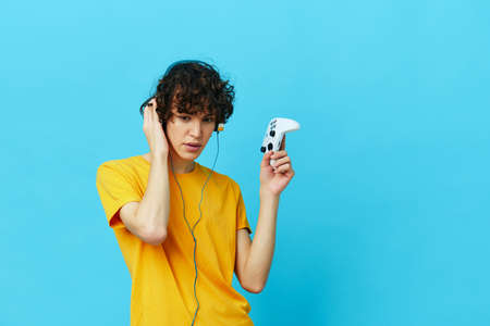 gamer yellow T-shirt with joystick video games blue backgroundの写真素材