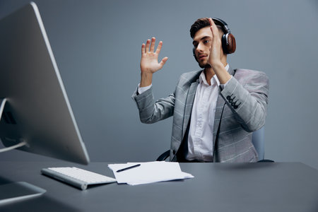 businessmen working at the computer in headphones in the office executive
