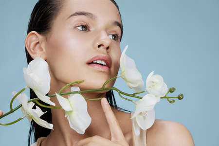 young woman flower skin care charm posing blue background