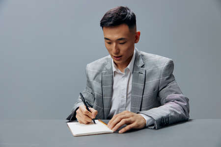 man writes in a notebook sits on the table dissatisfaction official Lifestyleの写真素材