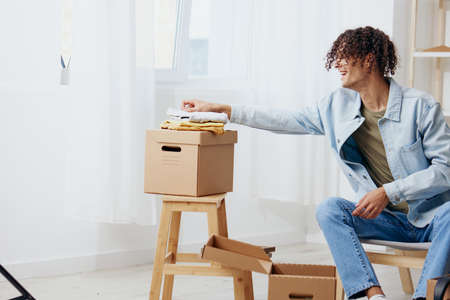 portrait of a man cardboard boxes in the room unpacking Lifestyleの写真素材