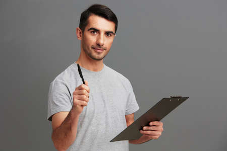 Cheerful man folder for papers holding a pen posing lifestyle cropped viewの写真素材