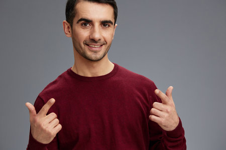 successful man posing gesture hands red sweater isolated backgroundの写真素材