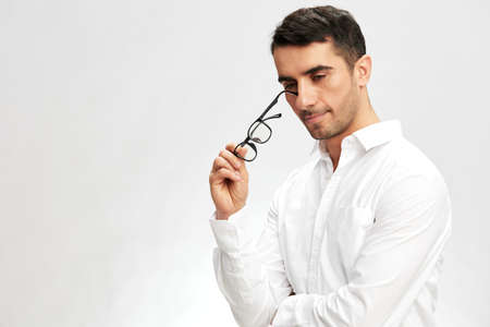 man in a white shirt, glasses, a pensive look, self-confidence business and office concept