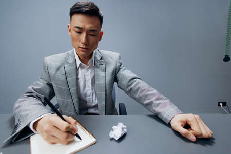 Asian man sits in the office emotions nervous breakdown anger isolated backgroundの写真素材