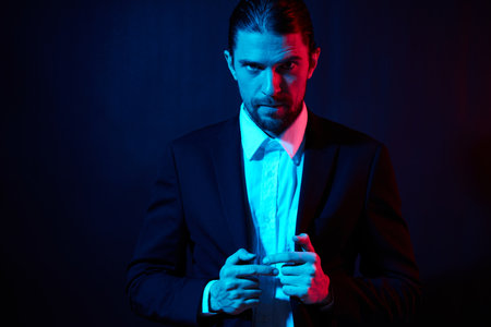 stylish man gestures with his hands attractive look neon lightの写真素材