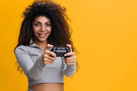 Young fun excited satisfied happy joyful woman 20s with afro hair wearing gray t-shirt hold in hand...