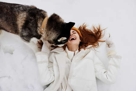young woman outdoors in a field in winter walking with a dog winter holidays