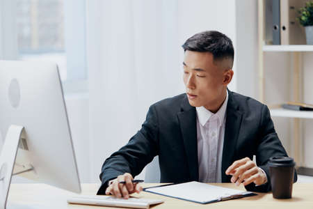 man works at the computer glass of coffee emotion office technologiesの写真素材