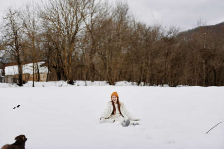 woman in the snow playing with a dog fun friendship winter holidaysの写真素材