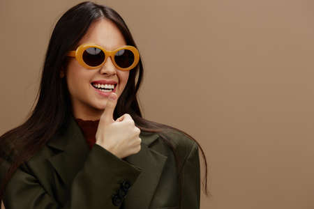 beautiful woman in a stylish suit in black glasses posing Gray backgroundの写真素材