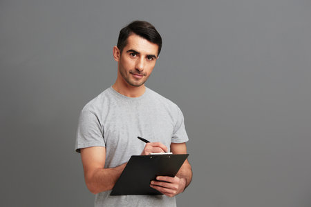 portrait man in gray t-shirt paper folder posing fun Gray background