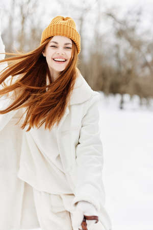 young woman in winter clothes in a hat fun winter landscape fresh airの写真素材