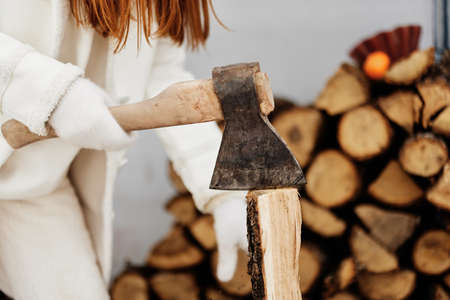 young woman on winter clothes firewood on the outdoors winter holidaysの写真素材