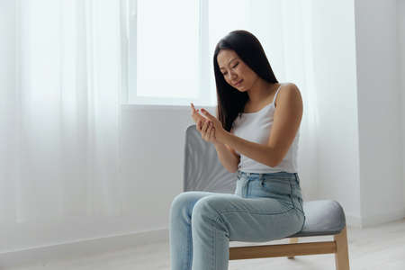 Broken hand Cramp. Upset suffering tanned beautiful young Asian woman touching massaging painful...