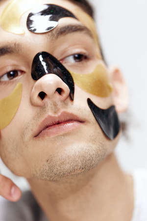 guy with curly hair black and gold patches on the face health cosmetology isolated background