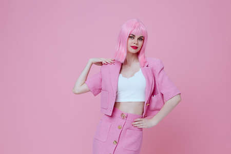 Young positive woman gestures with his hands with a pink jacket Studio Model unalteredの写真素材