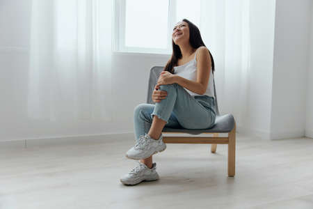 Cramp Broken Toe Broken Bone in Leg. Tormented suffering tanned beautiful young Asian woman touch leg at home interior living room. Injuries Poor health Illness concept. Cool offer Bannerの写真素材