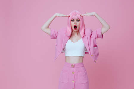 Young positive woman in a pink suit gesturing with his hands emotions fun color background unalteredの写真素材