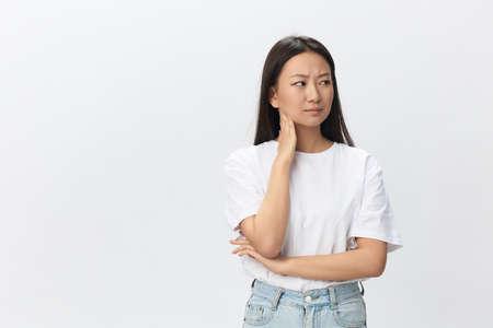 Tormented suffering tanned beautiful young Asian woman hurting holding painful elbow posing isolated...