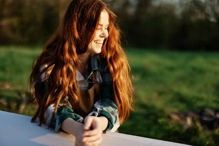 Portrait of a young woman with beautiful long red hair with a beautiful smile with teeth against a...