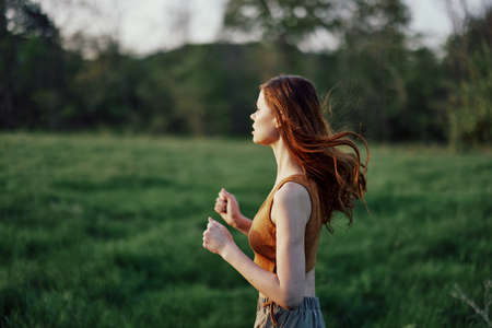 A woman is jogging with a focused face, tired after an outdoor activityの写真素材