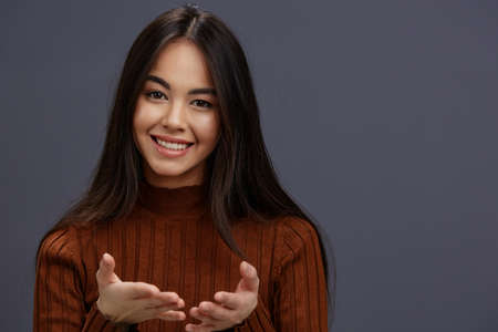 young woman hand gestures brown sweater fashion isolated backgroundの写真素材