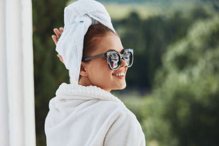 Attractive young woman in sunglasses at the hotel on the balcony Mountain Viewの写真素材
