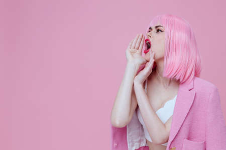 Beautiful fashionable girl in a pink suit gesturing with his hands emotions fun monochrome shot...