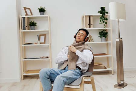 teenager wearing headphones sits in a chair rest technologiesの写真素材