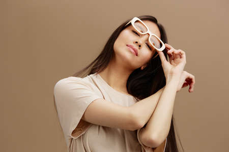 young woman in a beige T-shirt with glasses posing clothing fashion isolated background