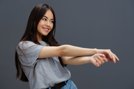 beautiful woman with long hair in a gray T-shirt gesturing with hands Lifestyleの写真素材