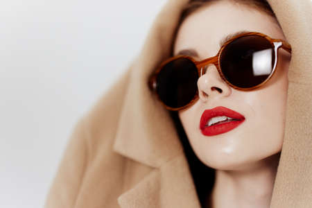 Close-up portrait of a models guns with a coat on his head on a white background. Catalog...