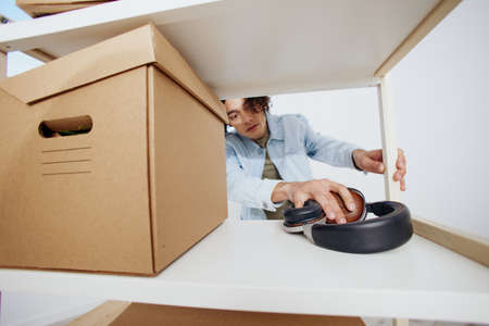 portrait of a man cardboard boxes in the room unpacking headphones sorting things out