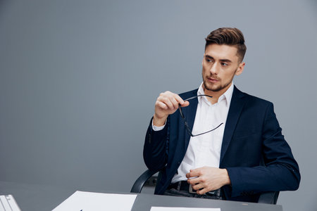 handsome businessman sitting at a desk in front of a computer isolated backgroundの写真素材