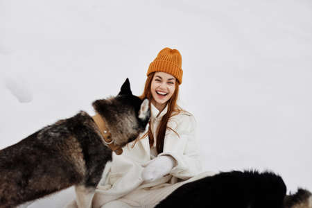 woman in the snow playing with a dogs fun friendship winter holidaysの写真素材