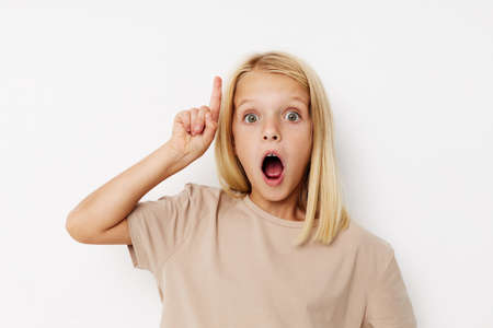 happy child beige t-shirts grimace on a light backgroundの写真素材