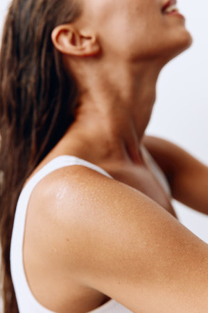A woman with long, wet hair sits with her head tilted back after washing. Taking care of your hair and scalpの写真素材