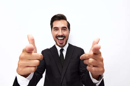 Portrait of a man in an expensive business suit close-up wide-angle lens pulls his hands into the camera with open mouth surprise happiness and shows thumbs up on white background, copy spaceの写真素材