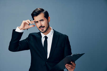 An angry business man with a headache is holding a folder of notes in his hands with a pen screaming into the camera. Business and technology in copy space managementの写真素材