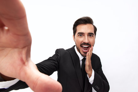 Portrait of a man in an expensive business suit close-up wide-angle lens pulls his hands into the camera with open mouth surprise happiness smile with teeth on a white background, copy spaceの写真素材