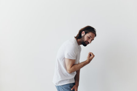 happy man listening to music and smiling in a white t-shirt on a white background happyの写真素材