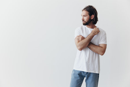 Portrait of a man with a black thick beard and long hair in a white T-shirt on a white isolated...