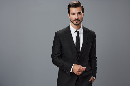 Man businessman in business suit and eyeglasses with brunette beard on gray background. The concept of good business and expensive clothes a copy spaceの写真素材