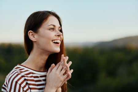 Young woman in a striped t-shirt smiles cutely on a journey against the backdrop of autumn natureの写真素材